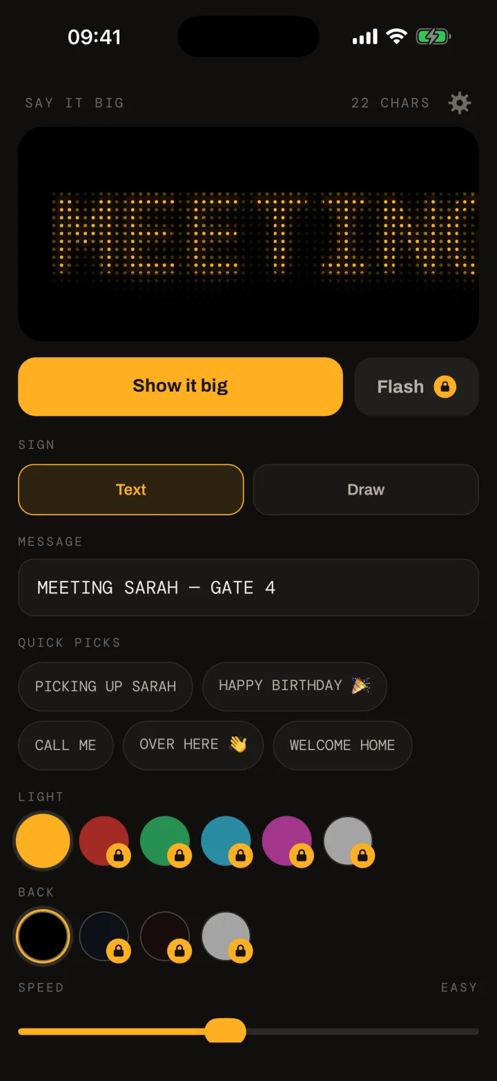 The Say In Bulbs editor: an amber dot-matrix preview of MEETING SARAH - GATE 4, a Show it big button, the message field, quick picks, light and background colour swatches, and the speed slider.