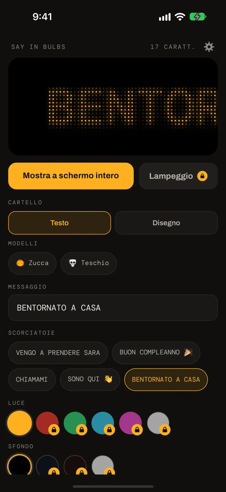 L'editor di Say In Bulbs: anteprima ambra a matrice di punti con BENTORNATO A CASA, il pulsante Mostra a schermo intero, i modelli Zucca e Teschio, il campo del messaggio, le scorciatoie e i campioni di colore per luce e sfondo.