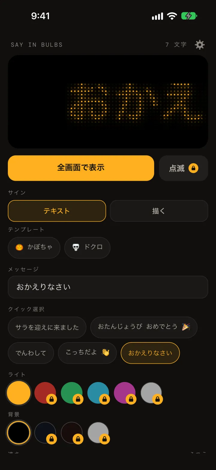 Say In Bulbs のエディタ。アンバーのドットマトリクスで「おかえりなさい」を表示したプレビュー、「全画面で表示」ボタン、テンプレートのかぼちゃとドクロ、メッセージの入力欄、クイック選択、ライトと背景の色見本。