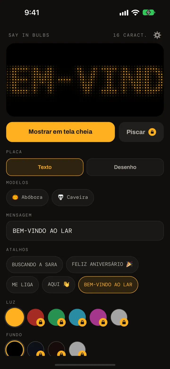 O editor do Say In Bulbs: uma prévia em matriz de pontos âmbar de BEM-VINDO AO LAR, o botão Mostrar em tela cheia, os modelos Abóbora e Caveira, o campo de mensagem, os atalhos e as amostras de cor de luz e de fundo.